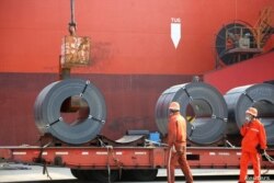 Trabajadores cargan productos de acero para su exportación a un buque de carga en un puerto en Lianyungang, provincia de Jiangsu, China, el 27 de mayo de 2020.