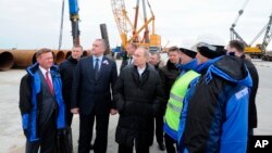 Le président russe Vladimir Poutine visite le chantier de construction du pont du détroit de Kertch, sur l'île de Tuzla, en Crimée, le 18 mars 2016. 