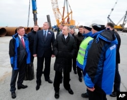 Russian President Vladimir Putin (S) visits the construction site of the Kerch Strait bridge on Tuzla Island, Crimea, March 18, 2016. Putin traveled to Crimea to mark the second anniversary of the peninsula's seizure from Ukraine.