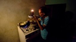 Một người Venezuela phải dùng nến thắp sáng để nấu ăn.
