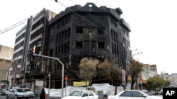 Traffic passes a building that was set ablaze during recent protests in Tehran, Nov. 20, 2019. 