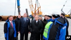 Russian President Vladimir Putin (S) visits the construction site of the Kerch Strait bridge on Tuzla Island, Crimea, March 18, 2016. Putin traveled to Crimea to mark the second anniversary of the peninsula's seizure from Ukraine.