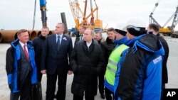 Russian President Vladimir Putin (S) visits the construction site of the Kerch Strait bridge on Tuzla Island, Crimea, March 18, 2016. Putin traveled to Crimea to mark the second anniversary of the peninsula's seizure from Ukraine.