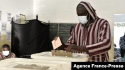 A voter casts the ballot paper at a voting station in Dakar, Jan. 23, 2022, during the 2022 municipal elections in Senegal.