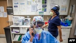 Registered nurse Carmen Verano talks on the phone in the Intensive Care Unit (ICU) at Providence Cedars-Sinai Tarzana Medical Center in Tarzana, California, Dec. 18, 2020.