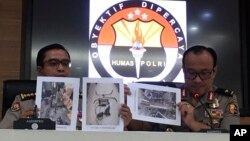 At a press conference in Jakarta, Indonesian National Police spokesperson Brig.Gen. Dedi Prasetyo, right, and an aide show photos of evidence of confiscated items during raids following a knife attack against an Indonesian official, Oct. 14, 2019. 