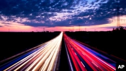 Long exposure picture shows driving cars on the highway just before sunrise near Frankfurt, central Germany.