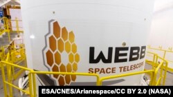 At Europe’s Spaceport in French Guiana, the finishing touches to the Ariane 5 fairing for the James Webb Space Telescope include the application of NASA, ESA and Canadian Space Agency logos and Webb insignia.