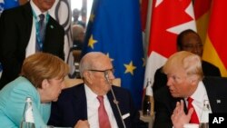 Presiden Amerika Serikat Donald Trump (kanan) dan Kanselir Jerman Angela Merkel (kiri) berbicara dengan Presiden Tunisia Beji Caid Essebsi (tengah) saat menghadiri pertemuan meja bundar pemimpin G7 di Hotel San Domenico di Taormina, Italia, 27 Mei 2017.