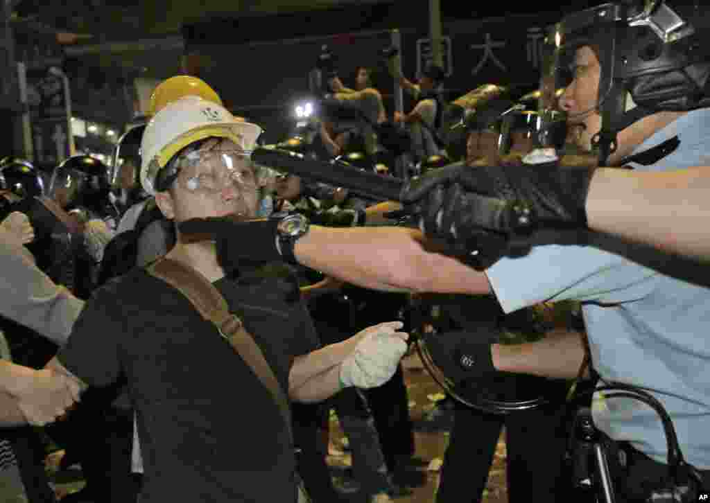 Police officers scuffle with protesters at an occupied area in the Mong Kok district of Hong Kong early, Nov. 26, 2014.