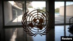 FILE - The United Nations logo is seen on a window in an empty hallway at United Nations headquarters in New York.