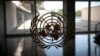 FILE - The United Nations logo is seen on a window in an empty hallway at United Nations headquarters in New York.