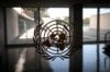 FILE - The United Nations logo is seen on a window in an empty hallway at United Nations headquarters in New York.