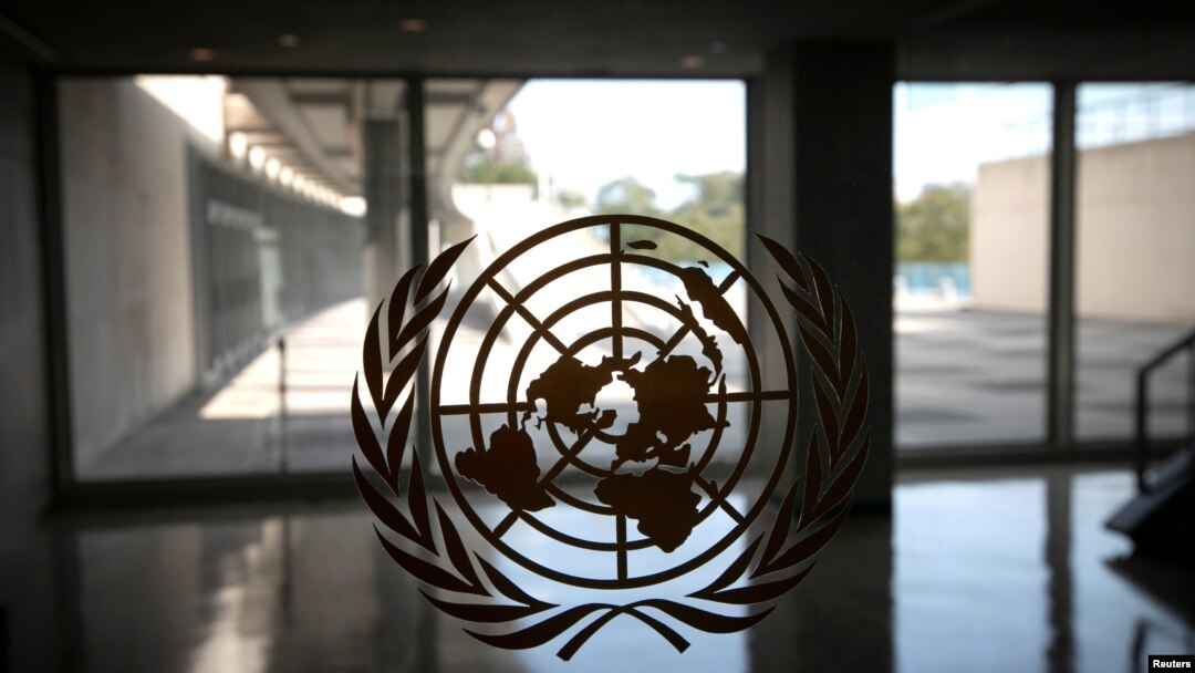 FILE - The United Nations logo is seen on a window in an empty hallway at United Nations headquarters in New York.