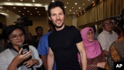 Telegram co-founder Pavel Durov, center, smiles as he leaves after a press conference following his meeting with Indonesian Communication and Information Minister Rudiantara in Jakarta, Indonesia, Aug. 1, 2017.