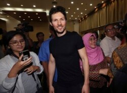 FILE - Telegram co-founder Pavel Durov, center, smiles as he leaves after a press conference following his meeting with Indonesian Communication and Information Minister Rudiantara in Jakarta, Indonesia, Aug. 1, 2017.