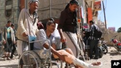 In this Nov. 23, 2015 photo, wounded people gather during a protest demanding treatment and an end to the blockade imposed by Shiite fighters, known as Houthis, in Taiz, Yemen's third largest city. 