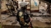 FILE - A Cameroonian elite Rapid Intervention Battalion (BIR) member patrols the abandoned village of Elona near Buea in the anglophone southwest region, Cameroon, Oct. 4, 2018. 