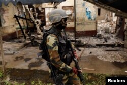 A Cameroonian elite Rapid Intervention Battalion (BIR) member patrols the abandoned village of Elona near Buea in the anglophone southwest region, Cameroon, Oct. 4, 2018.