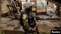 FILE - A Cameroonian elite Rapid Intervention Battalion (BIR) member patrols the abandoned village of Elona near Buea in the anglophone southwest region, Cameroon, Oct. 4, 2018. 