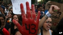 FILE - In this Oct. 22, 2014 file photo, people protest the disappearance of 43 students in Mexico City. 