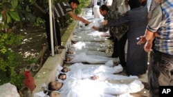 Syrian citizens trying to identify dead bodies, after an alleged poison gas attack by government forces.