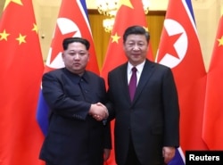 Lãnh tụ Triều Tiên Kim Jong Un và Chủ tịch TQ Tập Cận Bình bắt tay tại Đại Sảnh đường Nhân dân ở Bắc Kinh, TQ. Ảnh trao cho Reuters hôm 28/3/2018.