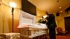 Wayne Bright, director de la funeraria de Wilson Funeral Home, arregla flores en un ataúd antes de un servicio, el 2 de septiembre de 2021, en Tampa, Florida.