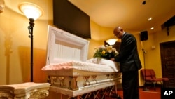 Wayne Bright, director de la funeraria de Wilson Funeral Home, arregla flores en un ataúd antes de un servicio, el 2 de septiembre de 2021, en Tampa, Florida.