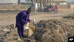 Mallam Muhammadu scavenges a trash dump in the city of Yola, in northeastern Adamawa state, Nigeria, February 14, 2012. He uses the bullhorn to announce his arrival in neighborhoods, where offers to buy unwanted items he can fix and sell.