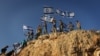 Children in the West Bank settlement of Itamar wave Israeli flags on a hilltop, Sept. 20, 2012. (VOA/Rebecca Collard)