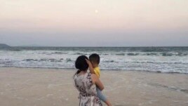 In this photo, Zou Xiaoqi, a single mother turned activist in Shanghai, holds her son as they visit a beach in Sanya, southern China's Hainan province in October, 2019. (Photo supplied by Zou Xiaoqi)
