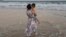 In this photo released by Zou Xiaoqi, Zou Xiaoqi, a single mother turned activist in Shanghai, holds her son as they visit a beach in Sanya, southern China's Hainan province in October, 2019. 