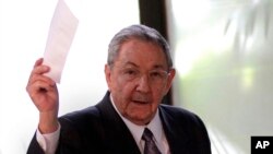 Cuba's President Raul Castro holds up the ballot of his brother Fidel, also present in the session, for president of the National Assembly during the opening session of the parliament in Havana, Cuba, Feb. 24, 2012. 