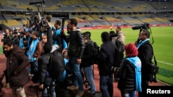 FILE - Egyptian photojournalists hold their cameras during a silent protest against preventing them by the officials from covering the Egyptian Premier League derby soccer match, west of Alexandria, Egypt, on February 9, 2016.