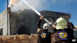 This photo provided by the Syrian Civil Defense group known as the White Helmets, shows Civil Defense workers putting out a fire in a house following airstrikes hit Maarat al-Nuaman town, in Idlib province, Syria, March 25, 2017.