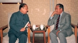 资料照片：1987年，中国前副总理习仲勋(左)在北京与达赖喇嘛的胞兄嘉乐顿珠交谈。