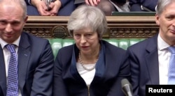 Prime Minister Theresa May sits down in Parliament after the vote on May's Brexit deal, in London, Britain, Jan. 15, 2019 in this image taken from video.