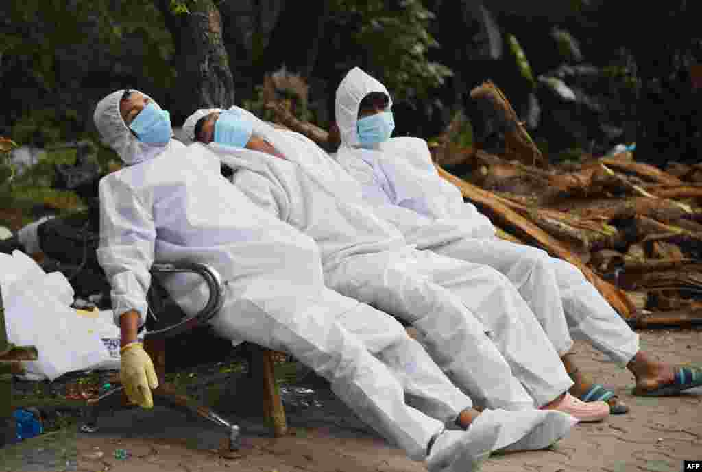 Ambulance staff rest on a bench after their COVID-19 duty at a crematorium ground in Guwahati, India.