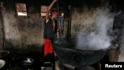 FILE - A man prepares food inside a community kitchen at a Hindu temple on the banks of the river Ganges in Kolkata, India, May 5, 2016. Forty students were hospitalized after consuming lunch in India's northwestern Rajasthan state Friday.