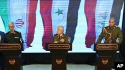 Syria's defense minister Gen. Ali Ayoub, center, holds a news conference with Iran's Chief of Staff of Armed Forces, Maj. Gen. Mohammad Hossein Bagheri, left, and Iraqi army commander, Gen. Osman Ghanemi in Damascus, Monday, March 18, 2019.