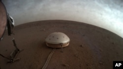 Dans cette image non datée mise à disposition par la NASA le jeudi 22 juillet 2021, des nuages ​​dérivent au-dessus du sismomètre SEIS recouvert d'un dôme de l'atterrisseur InSight sur Mars.