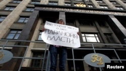Rossiyadagi nodavlat tashkilotlarga qarshi siyosatdan norozi namoyishchi, Moskva, 6-iyul 2012-yil.