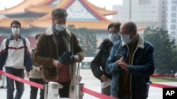 People wear face masks to protect against the spread of the new coronavirus as they visit the Chiang Kai-shek Memorial Hall in Taipei, Taiwan, Thursday, Feb. 27, 2020. As the worst-hit areas of Asia continued to struggle with a viral epidemic, with hundre