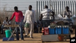 FILE - African migrants barbecue outside Holot detention center in the Negev Desert, southern Israel, April 21, 2015. Israeli authorities have begun distributing deportation notices to thousands of African migrants.