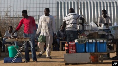 FILE - African migrants barbecue outside Holot detention center in the Negev Desert, southern Israel, April 21, 2015. Israeli authorities have begun distributing deportation notices to thousands of African migrants.