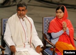 FILE - Nobel Peace Prize laureates Kailash Satyarthi and Malala Yousafzai listen to speeches during the Nobel Peace Prize awards ceremony at the City Hall in Oslo, Dec. 10, 2014.
