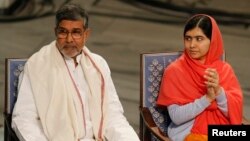 Kailash Satyarthi (kiri) dan Malala Yousafzai pada upacara di Oslo, Norwegia hari Rabu (10/12).