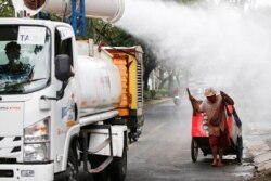 Petugas Palang Merah Indonesia menyemprotkan cairan disinfektan di kawasan Daan Mogot di tengah lonjakan kasus COVID-19 di Jakarta, Rabu, 30 Juni 2021. (Foto: Willy Kurniawan/Reuters)