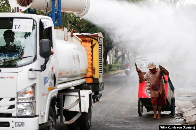 Petugas Palang Merah Indonesia menyemprotkan cairan disinfektan di kawasan Daan Mogot di tengah lonjakan kasus COVID-19 di Jakarta, Rabu, 30 Juni 2021. (Foto: Willy Kurniawan/Reuters)